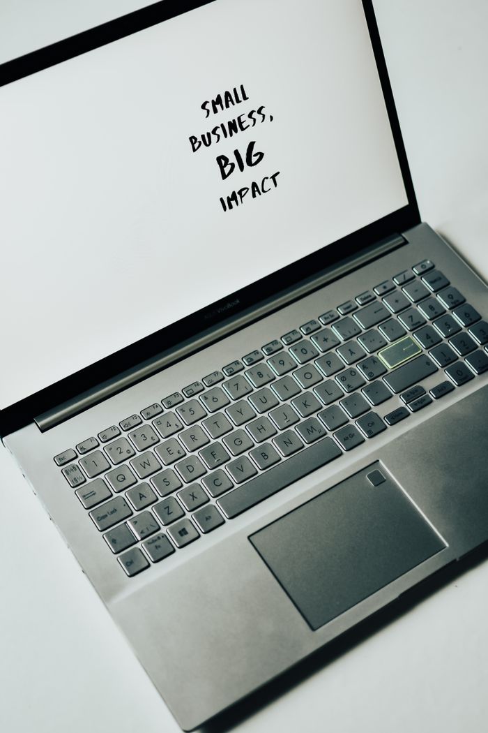 A laptop screen with the text 'Small Business, Big Impact,' symbolizing modern entrepreneurship.